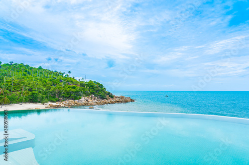 Fototapeta Naklejka Na Ścianę i Meble -  Beautiful outdoor infinity swimming pool in hotel resort with sea ocean view and white cloud blue sky