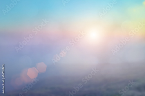 Natural background blurring warm colors and bright sun light. Bokeh or Christmas background Green Energy at sky sunny color orange light patterns plain abstract flare evening clouds blur.