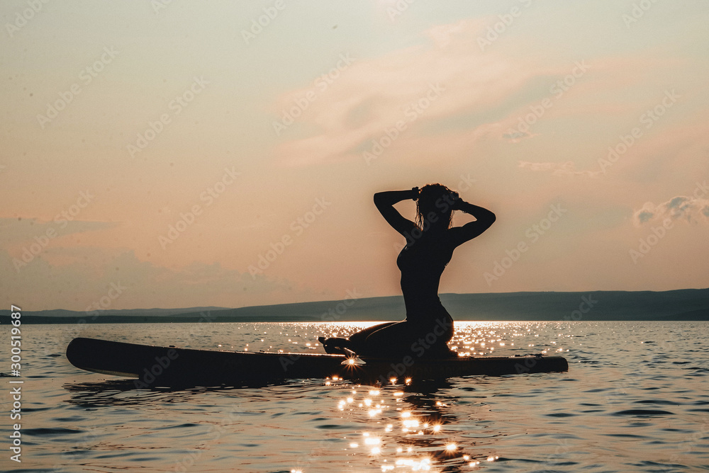 girl doing yoga on the water standing on a blackboard