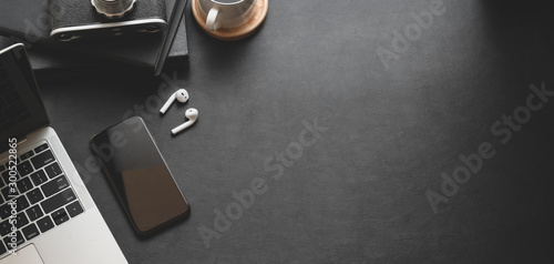 Top view of dark modern workplace with laptop computer and office supplies