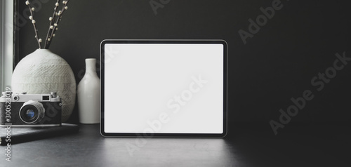 Close-up view of modern workplace with blank screen tablet with office supplies with ceramic decoration
