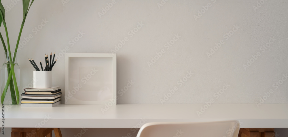 Minimal office room with mock up frame and office supplies with copy space on white table background Minimal office room with mock up frame and office supplies with copy space on white table background