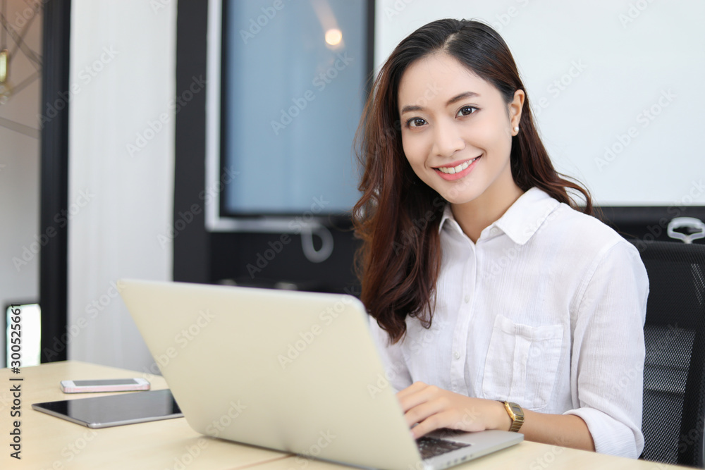 Asian business women using notebook and smiling happy for working Asian business women using notebook and smiling happy for working