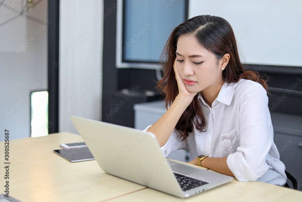 Asian business women using notebook and serious and headache for working Asian business women using notebook and serious and headache for working