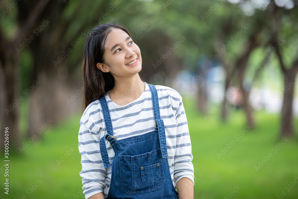 Smiling beautiful Asian girl at tree on park in summer for relax time Smiling beautiful Asian girl at tree on park in summer for relax time