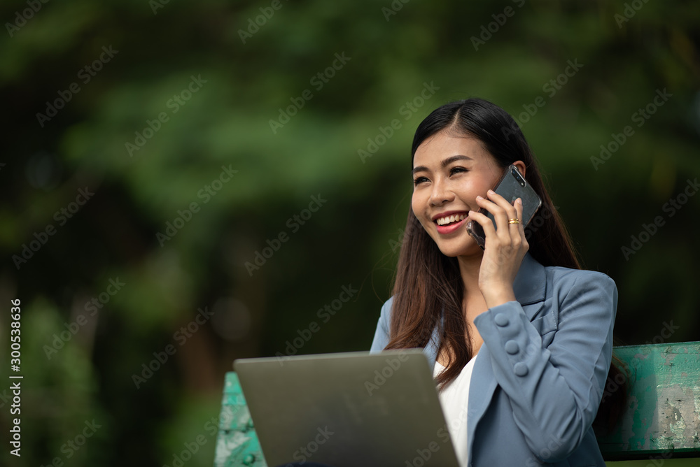happy businesswomen working with a laptop in a green park happy businesswomen working with a laptop in a green park