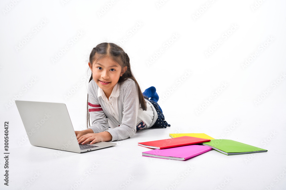 Asian Little kid with pile of books and laptop lying on white background, Education Learning School Concept Asian Little kid with pile of books and laptop lying on white background, Education Learning School Concept
