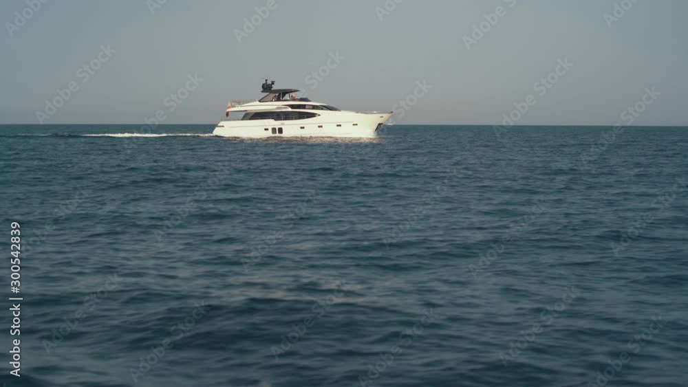 View of yacht near Ibiza island. Yachting around Balearic islands in the mediterranean sea. Unrecognizable people on yacht View of yacht near Ibiza island. Yachting around Balearic islands in the mediterranean sea. Unrecognizable people on yacht