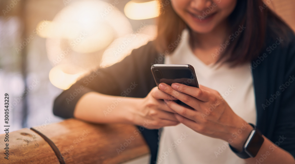 Close-up of woman using smartphone with typing an sms message to friends and walking in mall. Close-up of woman using smartphone with typing an sms message to friends and walking in mall.