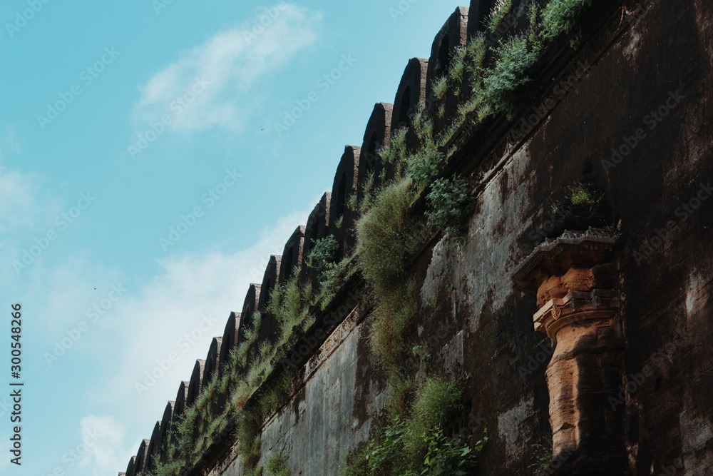 Closeup shot of the fort wall of the Uparkot Fort against the blue sky with clouds in Junagadh, Gujarat, India