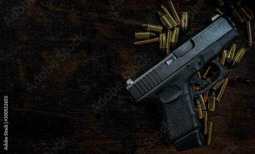 Guns and ammunition placed in a wooden table,Short guns and ammunition placed on a black background table,Guns and ammunition are ready to use.,Noisy weapon