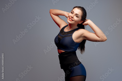 portrait of a young fitness woman in sportswear posing in studio