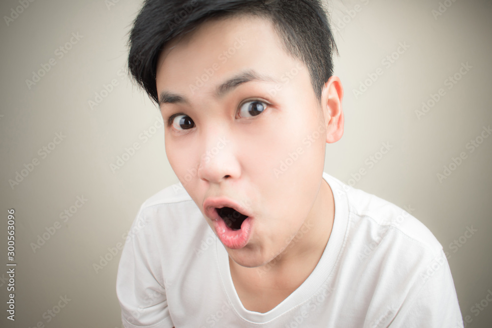 Shocked, Asian faces wearing white shirts on a gray background. Shocked, Asian faces wearing white shirts on a gray background.