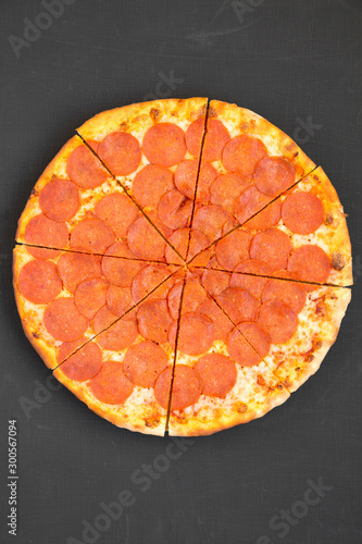 Delicious Pepperoni pizza over black background, top view. Overhead, from above, flat lay. Close-up.