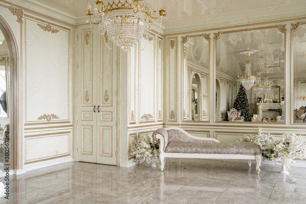 Naklejka premium Christmas morning. Classic luxurious apartments with decorated christmas tree and presents. Living with fireplace, columns and stucco.