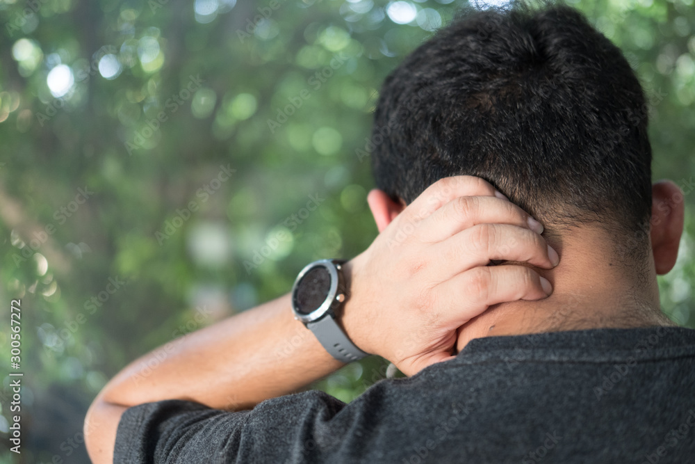 Man wearing gray t-shirt Suffering of neck ache injury, touching neck with hand Man wearing gray t-shirt Suffering of neck ache injury, touching neck with hand