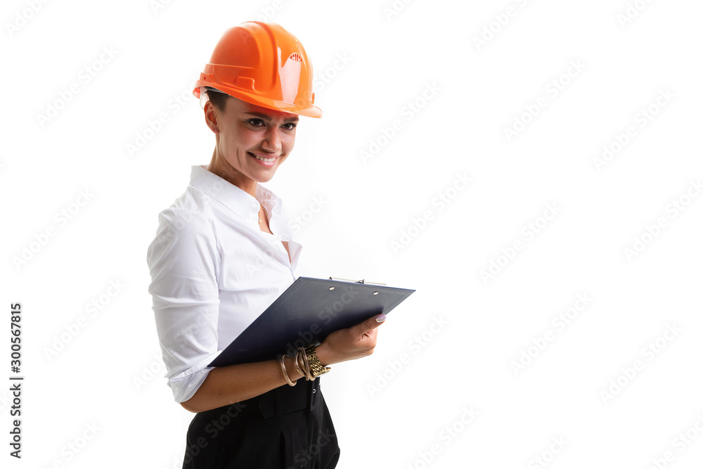Beautiful caucasian female in office clothes write notes and holds an orange construction helmet isolated on white background Beautiful caucasian female in office clothes write notes and holds an orange construction helmet isolated on white background