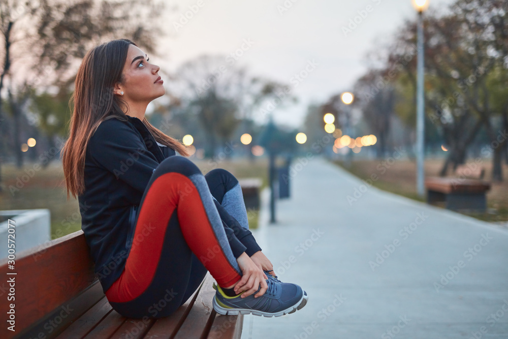 Young woman making pause after exercising in an urban park. Young woman making pause after exercising in an urban park.