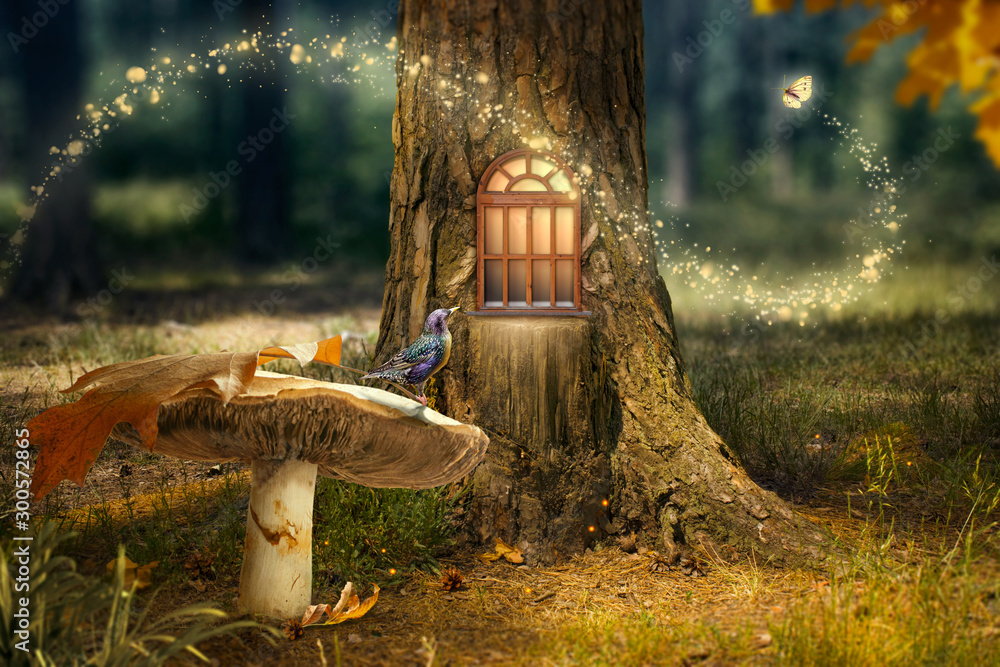 Fototapeta premium Zaczarowany las wróżek z magicznym lśniącym oknem w wydrążonym drzewie, dużym grzybem z ptakiem i latającym magicznym motylem opuszczającym ścieżkę ze świetlistymi iskierkami