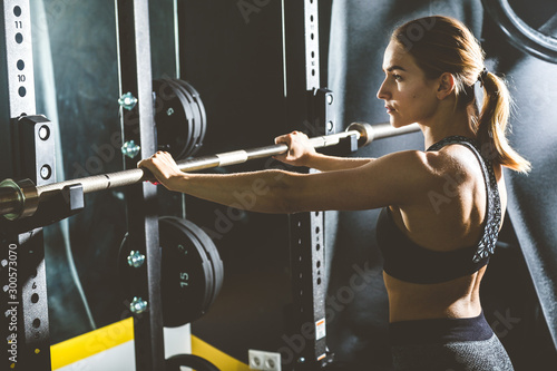 Working out with barbell weights at the gym.Fitness Women exercising are lifting dumbbells. Fitness muscular body.Workout at gym.