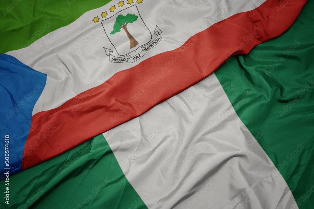 waving colorful flag of nigeria and national flag of equatorial guinea.