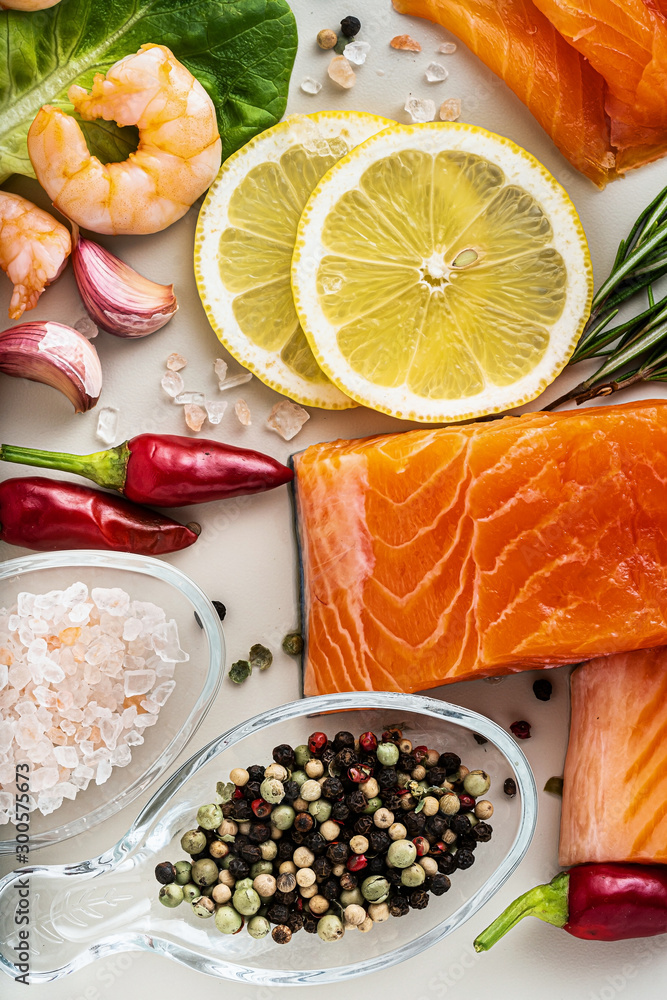 fresh seafood on a table with spices, vegetables and olive oil: fresh and smoked salmon, shrimp and crab sticks for a supermarket or fish sushi restaurant. fresh seafood on a table with spices, vegetables and olive oil: fresh and smoked salmon, shrimp and crab sticks for a supermarket or fish sushi restaurant.