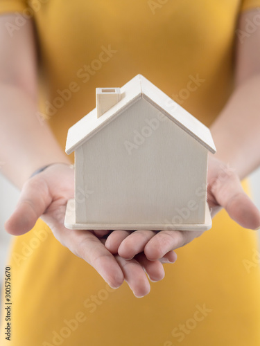 Asian woman holding house in her hands real estate concept.