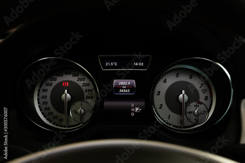 The dashboard of the car is glowing blue with red arrows at night with a speedometer, tachometer and other tools to monitor the condition of the vehicle in modern style on black isolated background