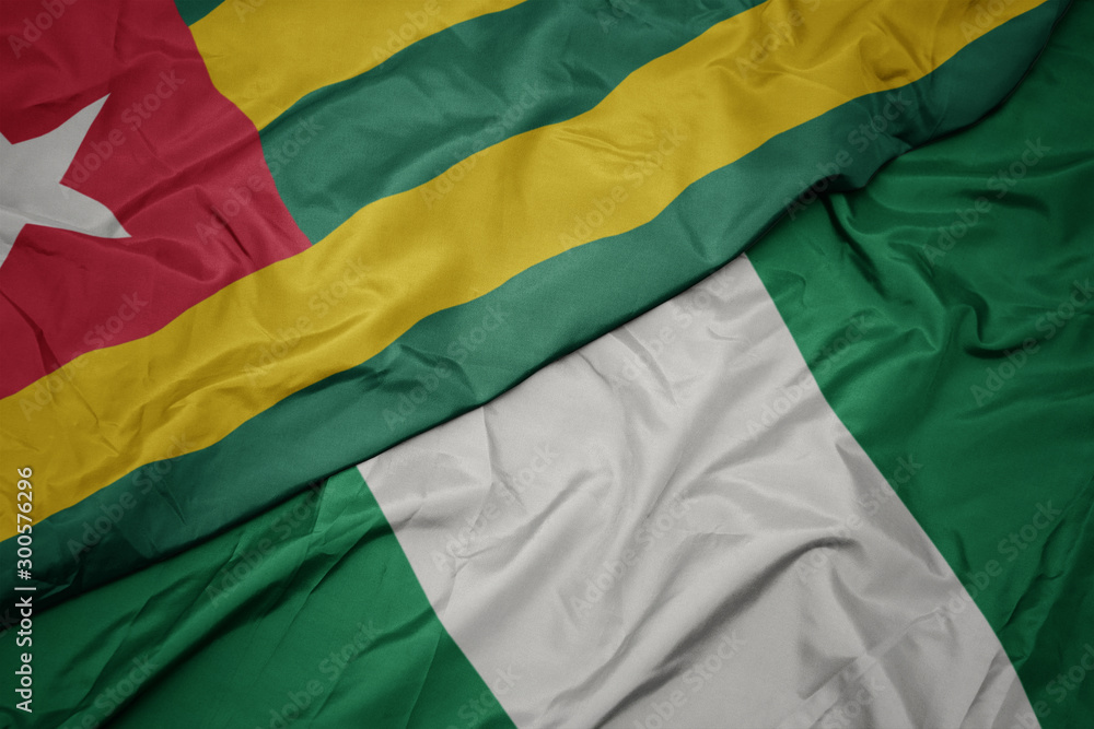 waving colorful flag of nigeria and national flag of togo.
