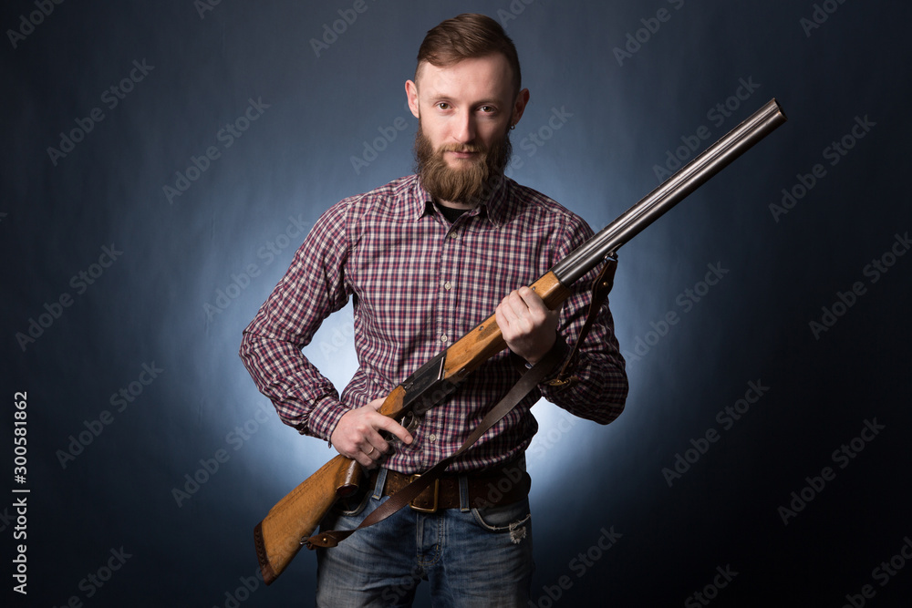 Man holding a shotgun on dark blue background. Man holding a shotgun on dark blue background.