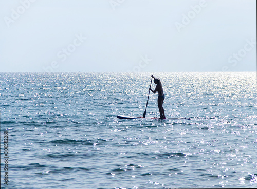 Girl on a sup in the shore of Torre San Giovanni