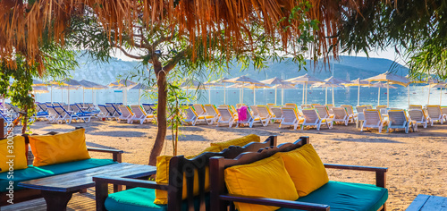 Fototapeta Naklejka Na Ścianę i Meble -  Beautiful beach on the shores of the calm blue bay of the Aegean Sea at sunset. Beach vacation and holiday destination concept. Bitez, Bodrum, Turkey