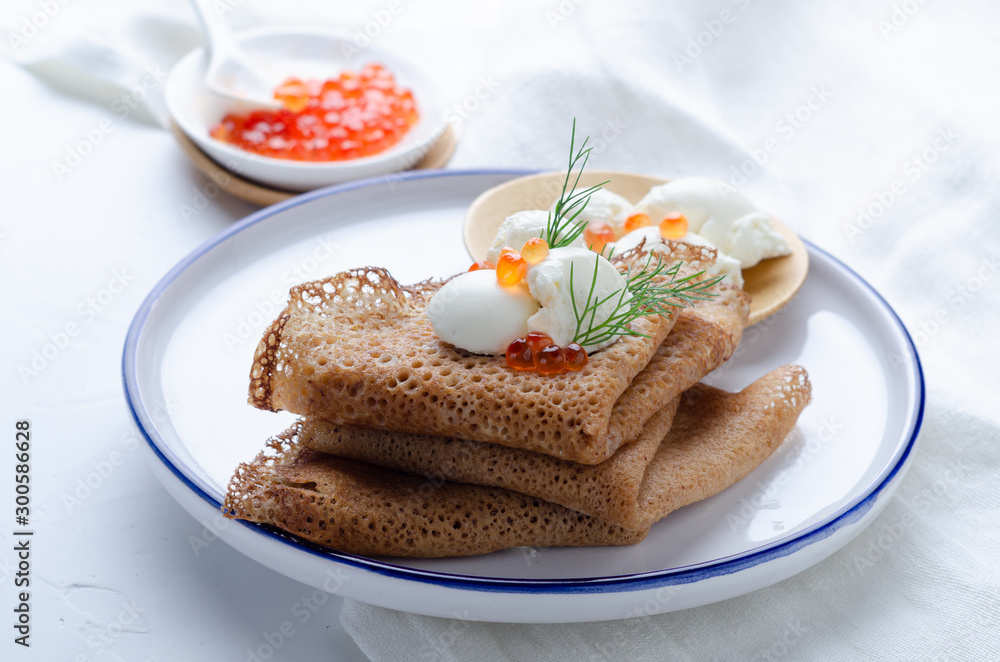 Russian pancakes with red caviar and sour cream. Russian pancakes with red caviar and sour cream.