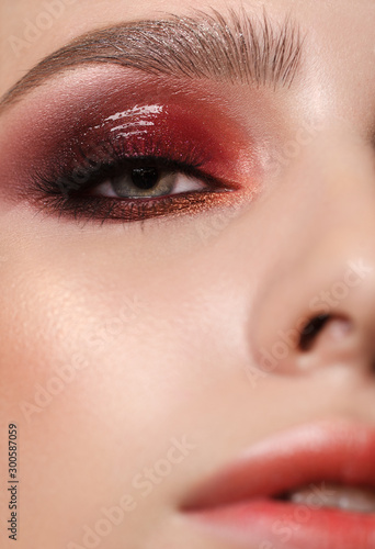 Attractive young beauty model with professional make up, perfect skin and nude lips. Trendy glossy colorful smoky eyes