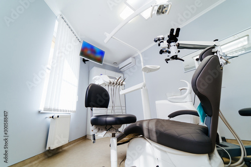 Modern dentistry office interior with chair and tools. Microscope in stomatology.