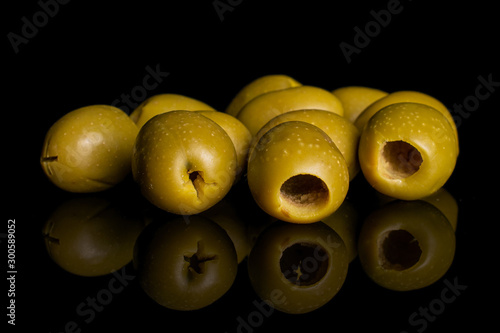 Lot of whole pitted green olive isolated on black glass