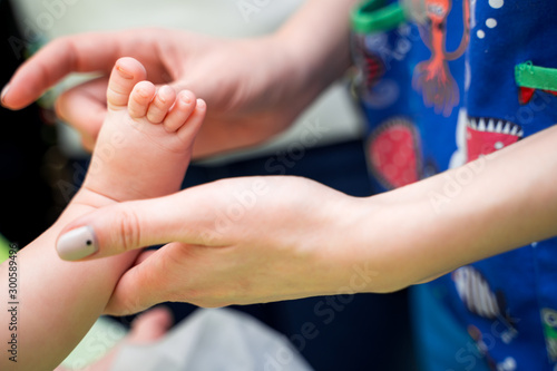 Pediatrician examining little baby in clinic. Closeup of a child's leg in doctor's hands.