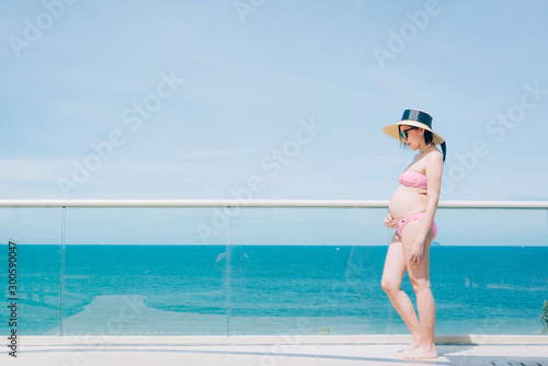 Happy pregnant woman relaxing outside at sea outdoor