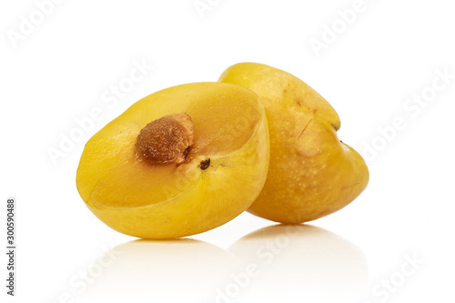 Group of two halves of fresh yellow plum isolated on white background