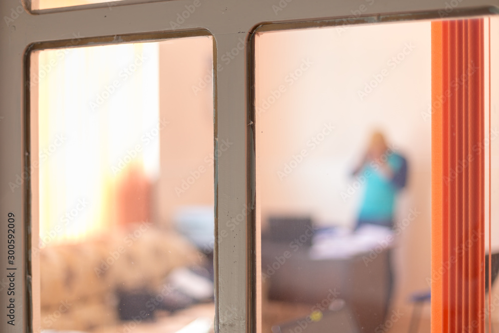 images from an office street, through a window with an orange curtain, silhouette of a man on a blurred background