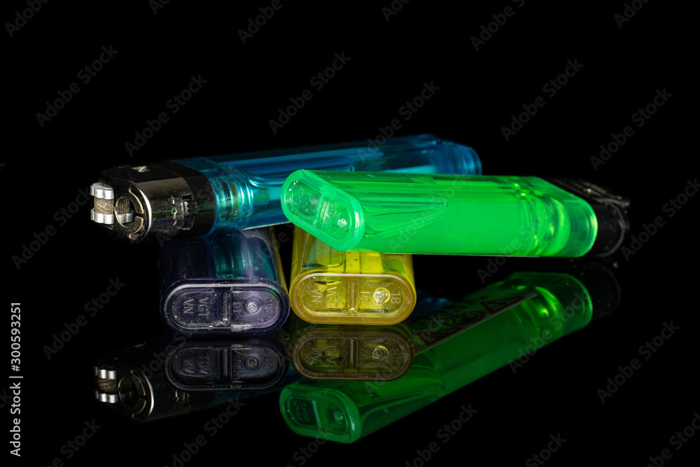 Group of four whole plastic lighter isolated on black glass Group of four whole plastic lighter isolated on black glass