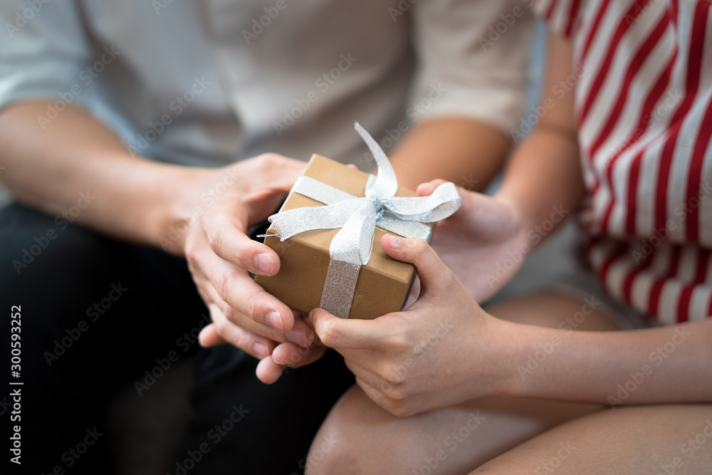 The hands of couples who are giving gift boxes to each other