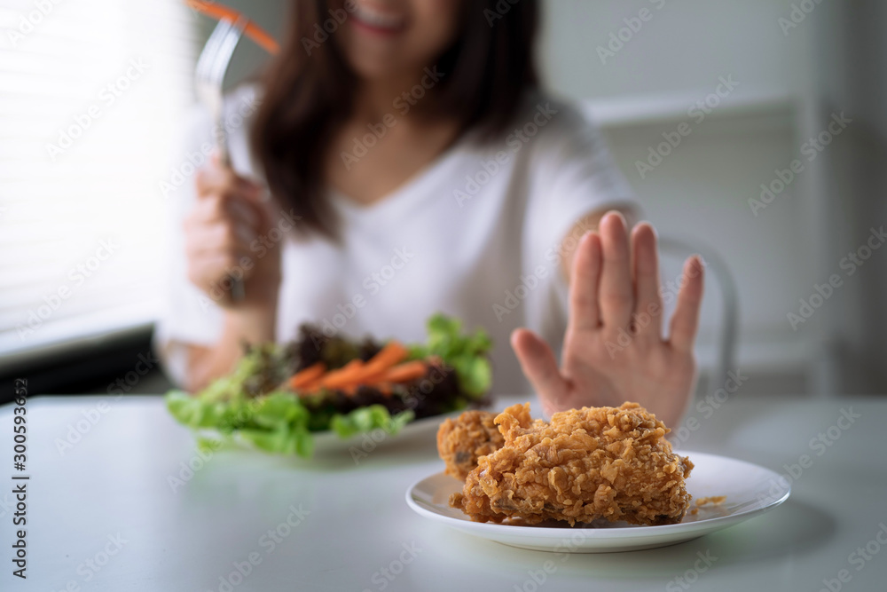 Dieting and good health concept, the young lady refused fried food and chose healthy food.