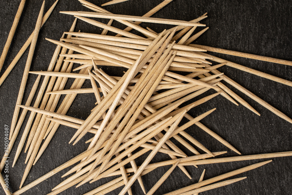 Lot of whole disordered wooden brown toothpick flatlay on grey stone Lot of whole disordered wooden brown toothpick flatlay on grey stone