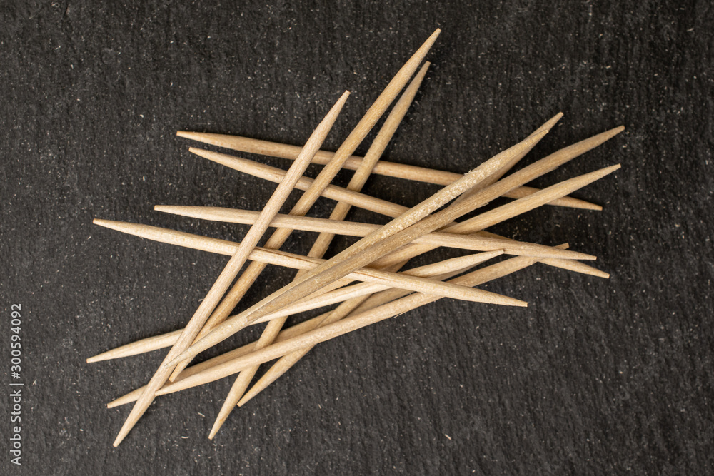 Lot of whole arranged wooden brown toothpick flatlay on grey stone Lot of whole arranged wooden brown toothpick flatlay on grey stone