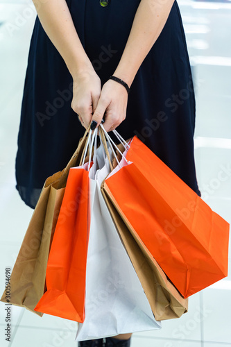 Paper bags with purchases in the hands of a girl in a supermarket. Shopping.Sales Concept