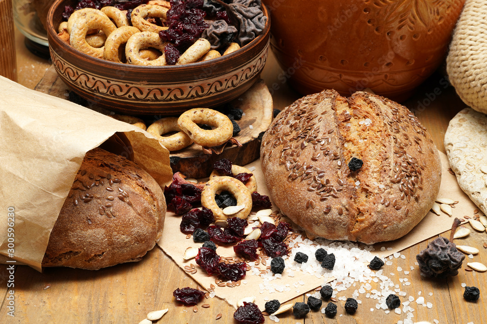 fresh bread, bagels, dried fruits, seeds, salt, jar and wheat on the wooden - still life and healthy eating concept fresh bread, bagels, dried fruits, seeds, salt, jar and wheat on the wooden - still life and healthy eating concept