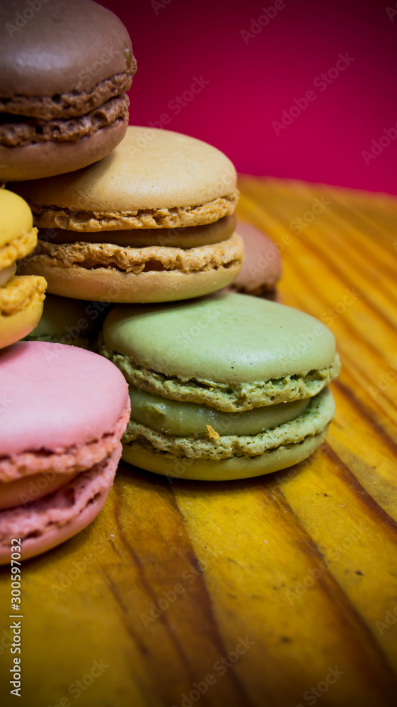 Colored macarons isolated on wooden dish, typical French dish