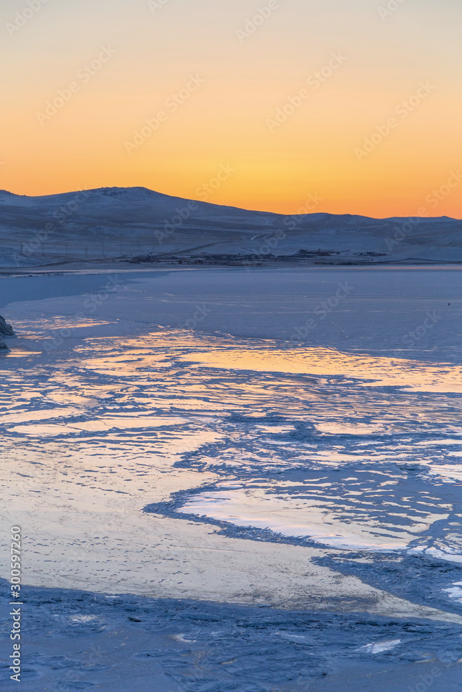 Colorful sunset over the crystal ice of Baikal lake