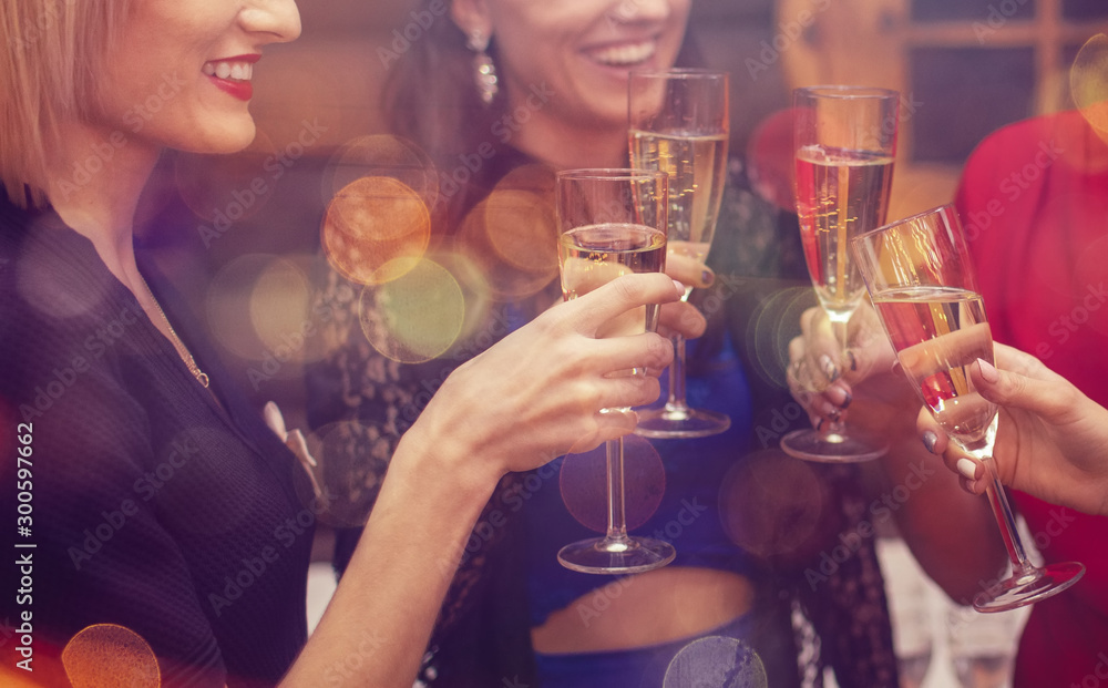 Woman's celebrating and toasting with champagne. Hands with a full glasses of sparkling wine - obrazy, fototapety, plakaty 